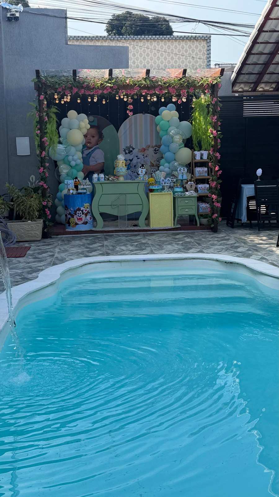 Piscina com a decoração da festa infantil ao fundo